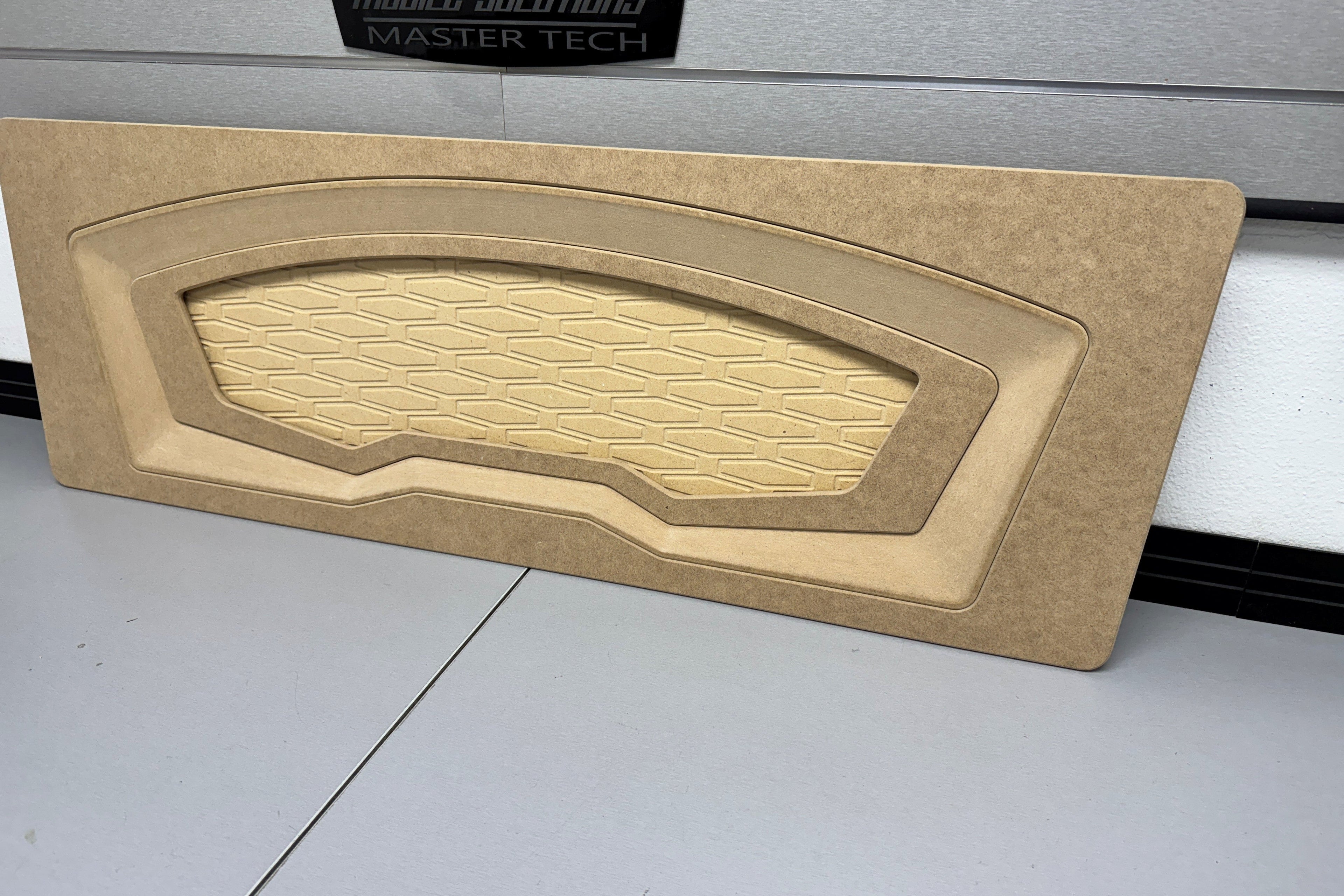 Beige car interior panel on a gray surface with 'Mobile Solutions Master Tech' branding.