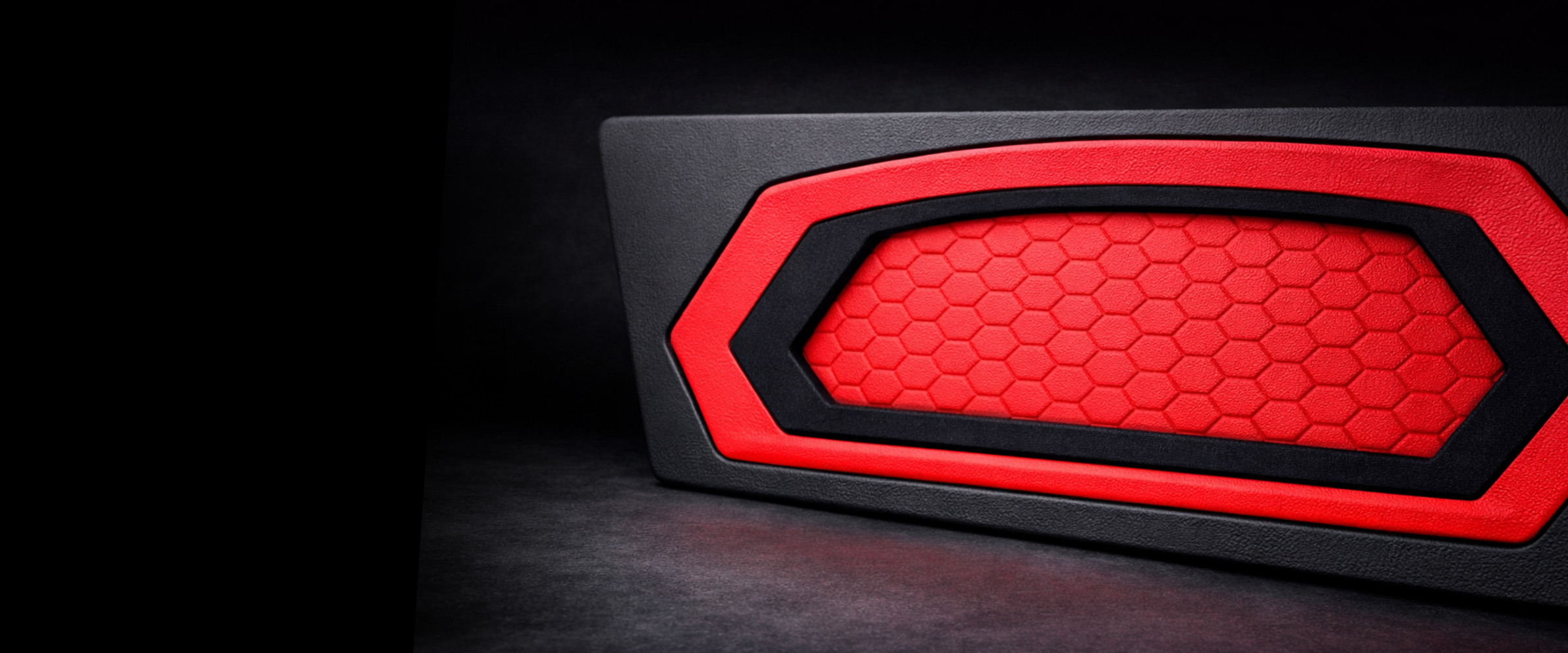 Red and black honeycomb patterned Grille on a dark background